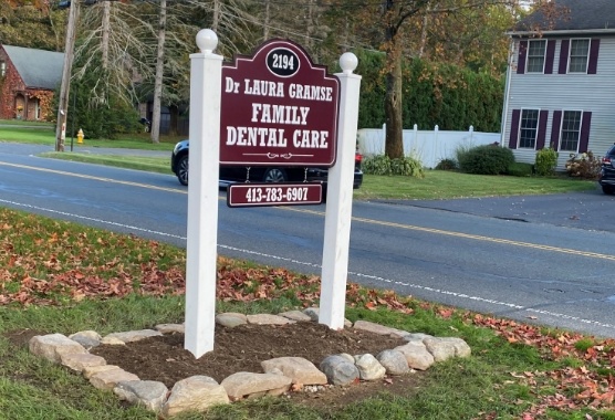 Maroon sign outside of dental office that reads Doctor Laura Gramse Family Dental Care