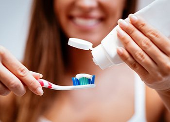 Woman squeezing toothpaste onto toothbrush