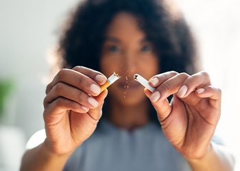 Woman breaking cigarette in half
