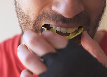 Man placing yellow mouthguard over upper arch