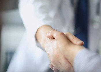 Close-up of dentist shaking hands with patient