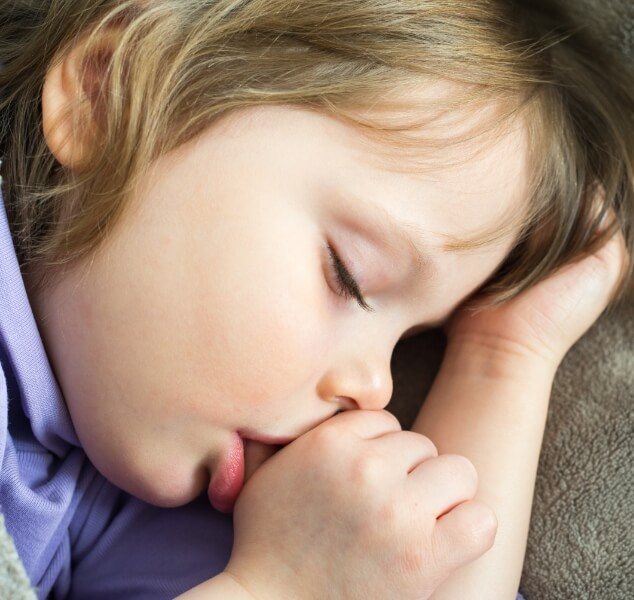Child sleeping while sucking their thumb