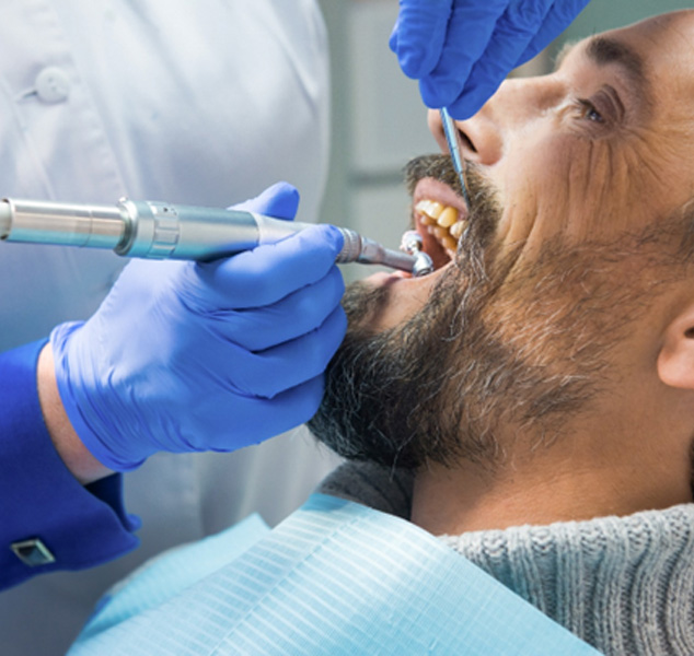 A middle-aged man receiving a dental cleaning