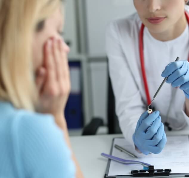 Dentist showing a model of a tooth to a patient