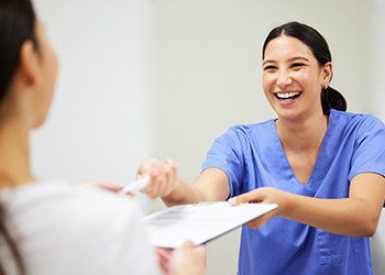 a patient being handed a dental insurance form