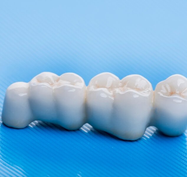 Dental bridge against light blue background