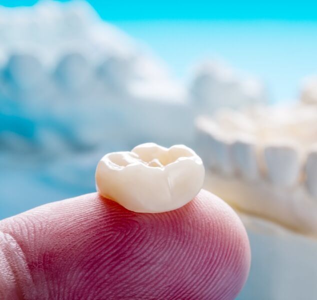 Dental crown resting on a finger