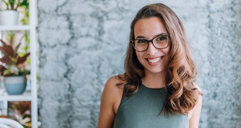 Woman smiling in front of gray wall