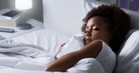 Woman holding pillow while sleeping