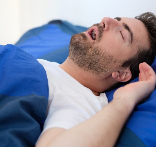 Man sleeping on his back with his mouth open needing sleep apnea treatment in Springfield
