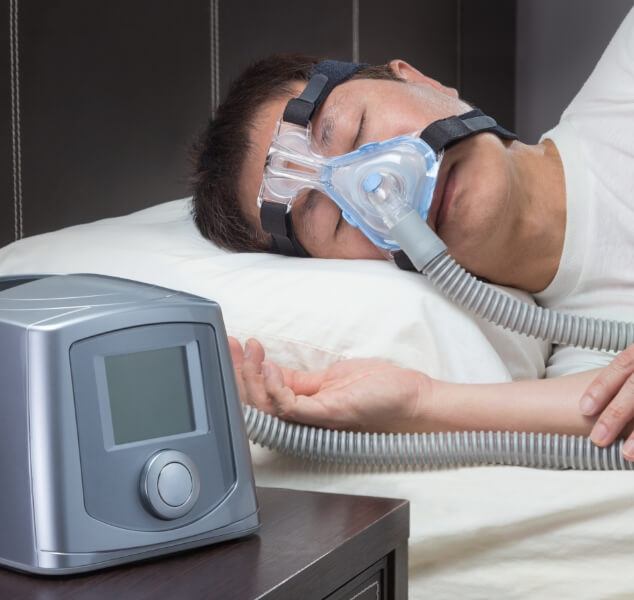 Man sleeping on his side while wearing C P A P mask