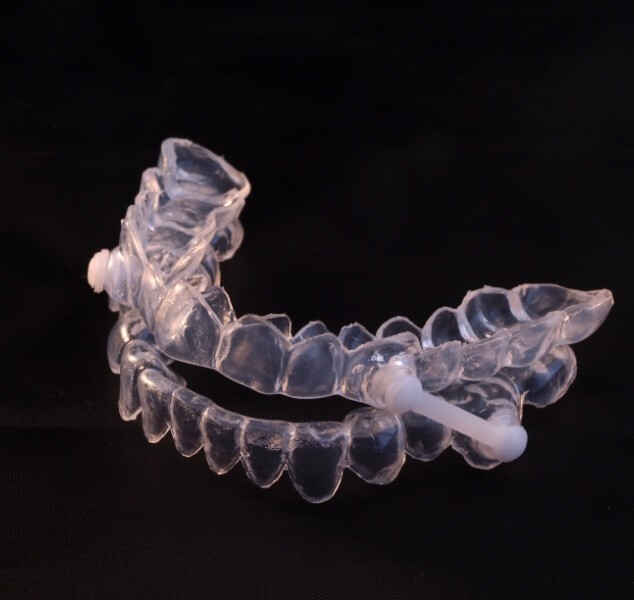 Clear oral appliance against black background