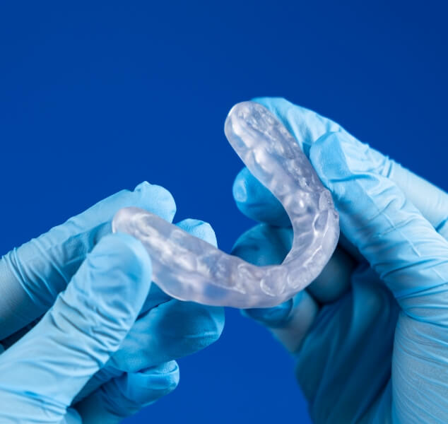 Dentist holding a clear occlusal splint tray