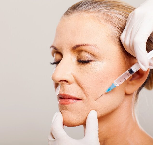 Woman receiving a Botox injection near her jaw joint