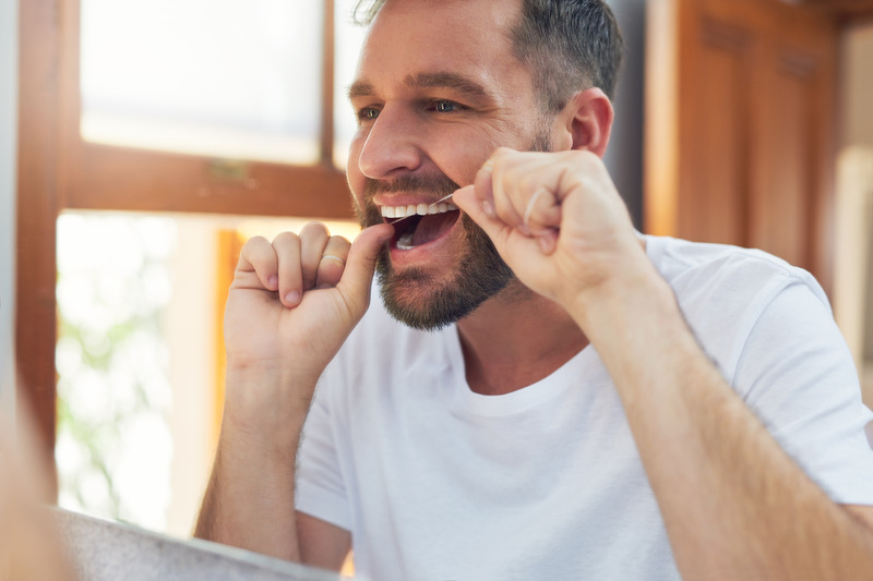 Patient flossing to prevent gum disease