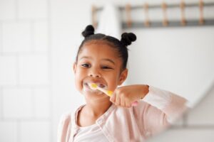 Kid brushing her teeth.