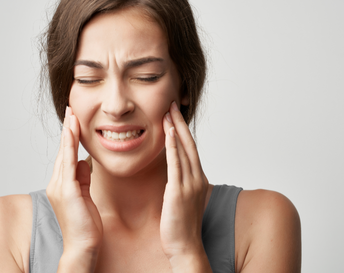 Woman holding jaw in pain