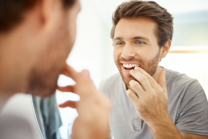 Patient smiling after getting new dental crowns